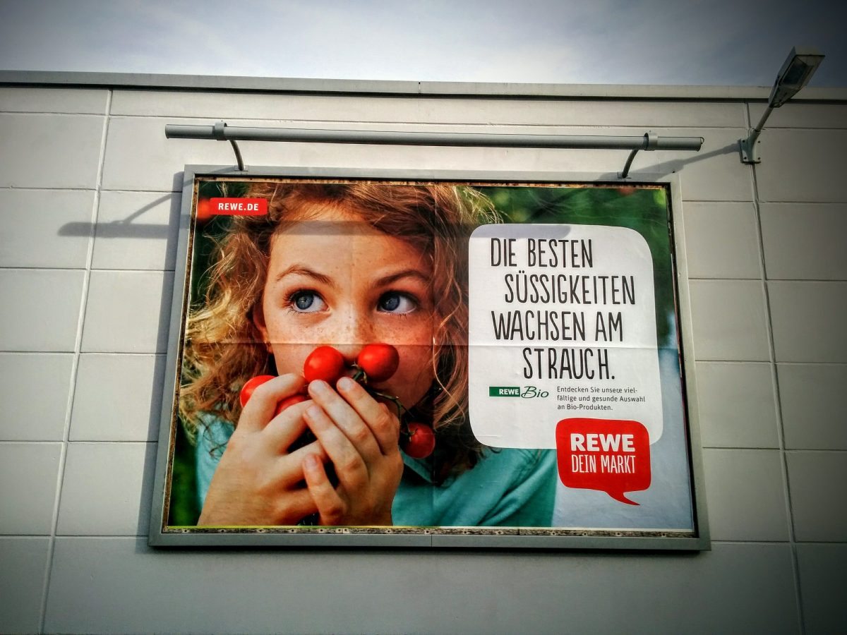 Foto einer Werbefläche des Rewe-Marktes.