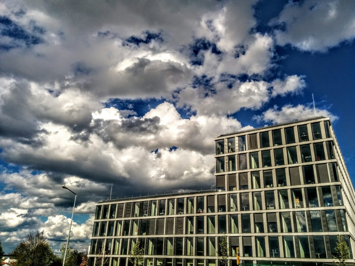 Blick auf das die TechBase Regensburg das Innovationszentrum von der Bushaltestelle gegenüber. Man sieht viele Wolken, denn der April macht was er will.