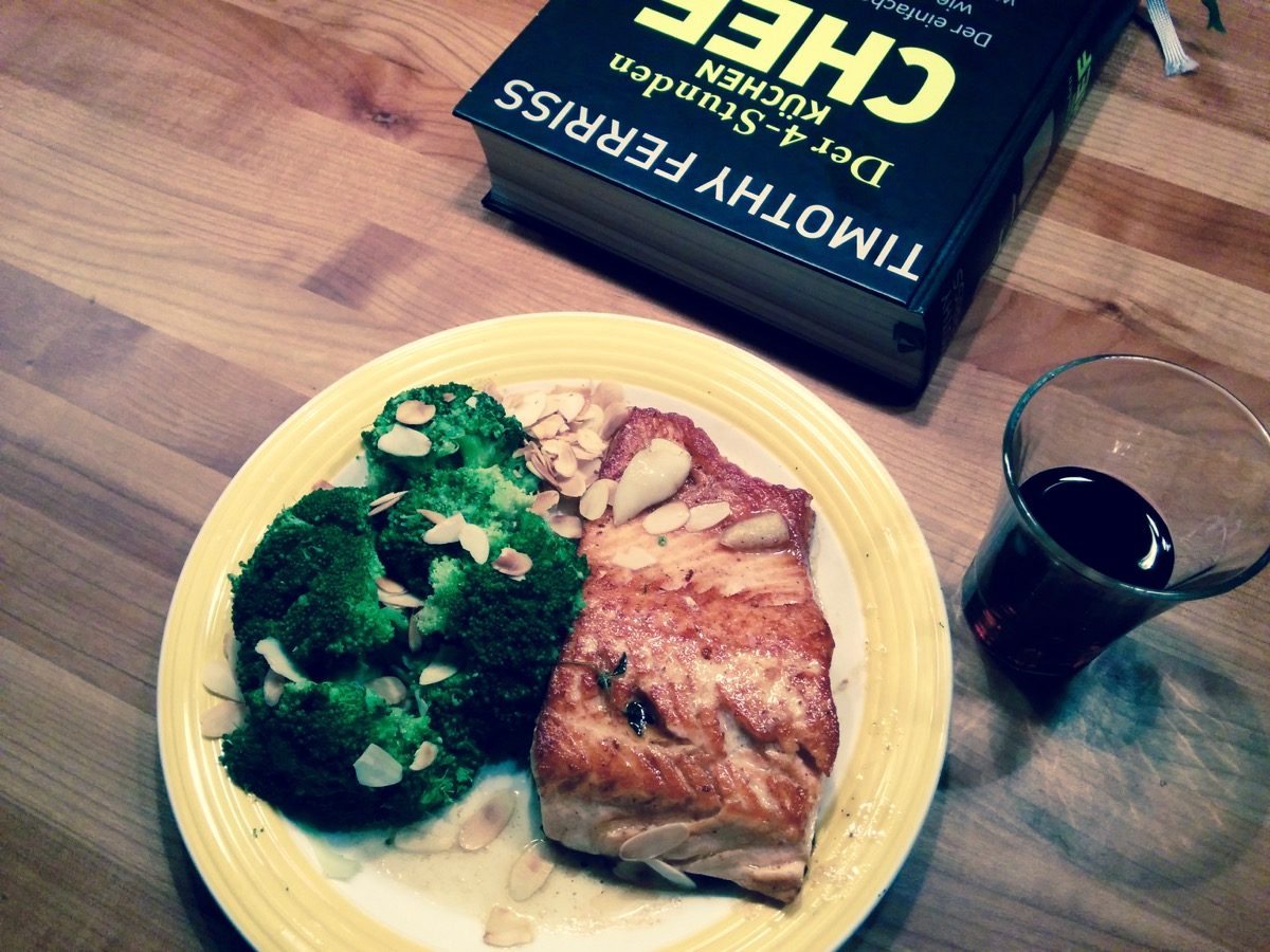 Foto von Lachs, Broccoli, Mandeln, Rotwein und einem Buch